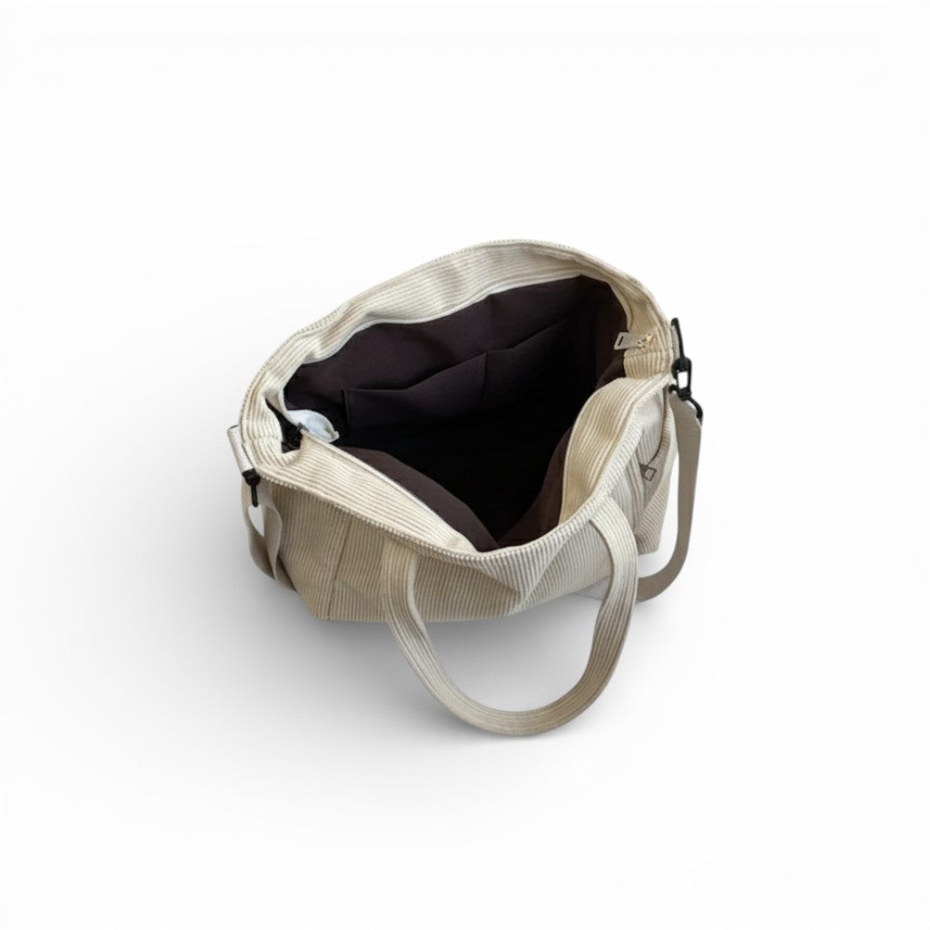 Beige tote bag with black interior on a white background