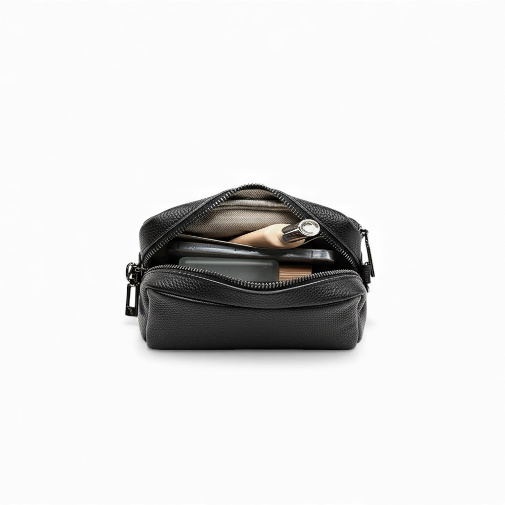 Black leather crossbody bag with a zipper on a white background