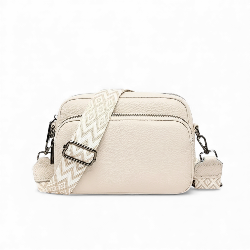 Beige crossbody bag with patterned strap on a white background