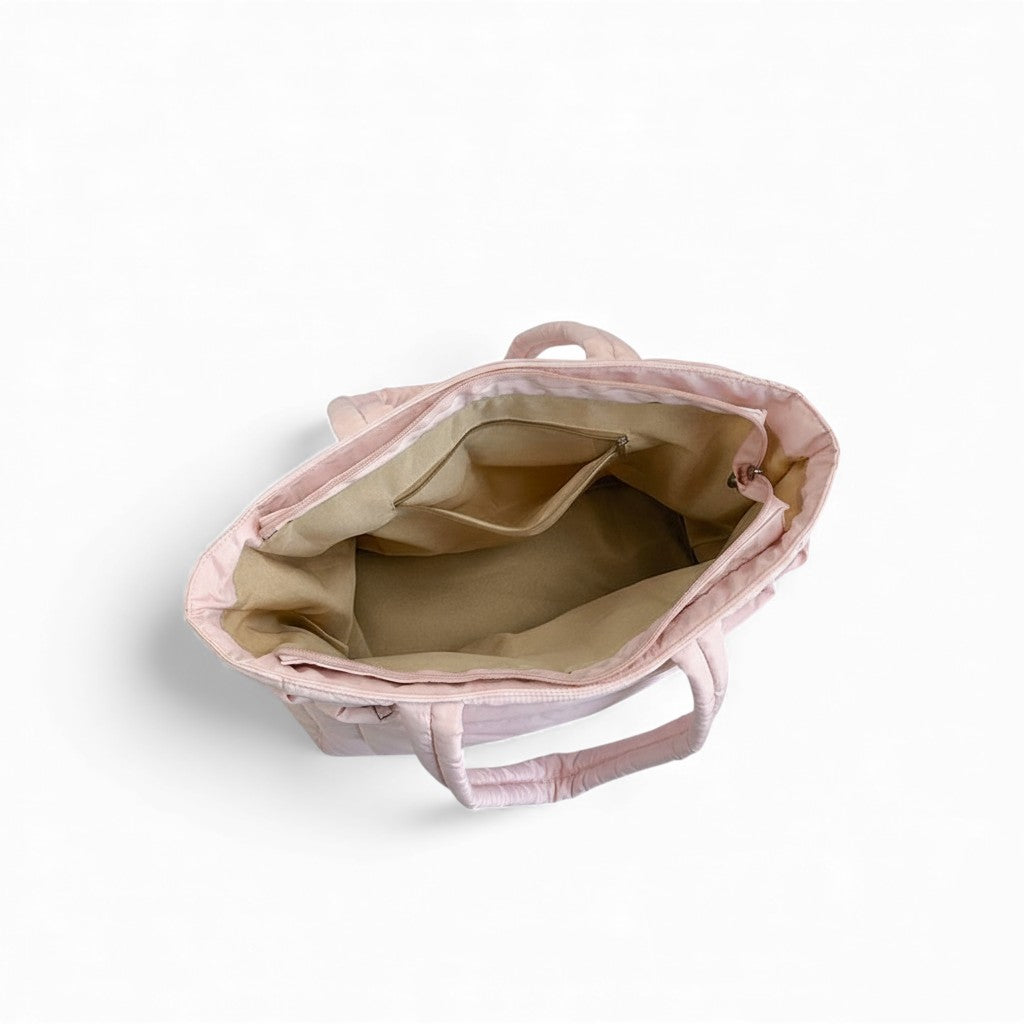 Pink tote bag with beige interior on a white background