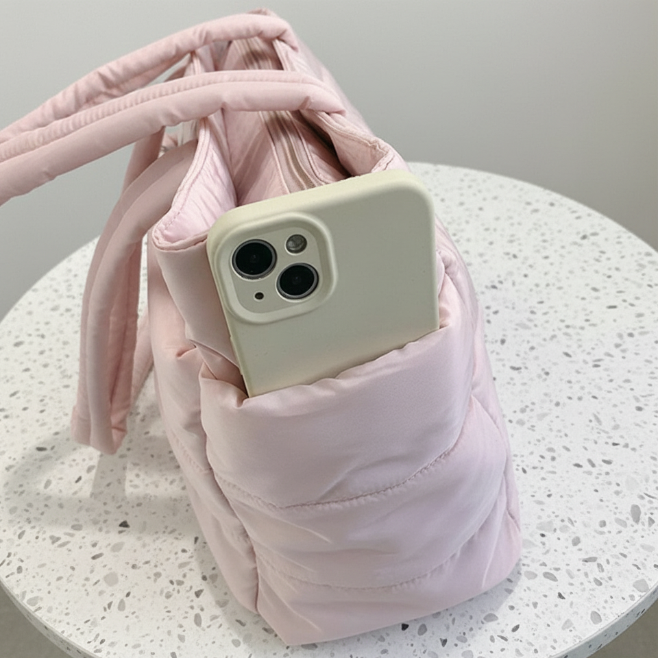 Iphone sitting in the sidepocket of a pink tote bag