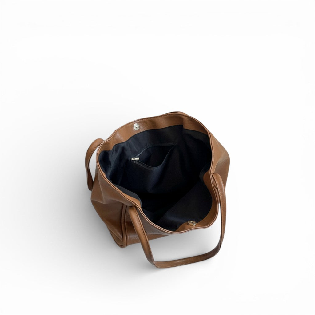 Brown leather bag with clear bottom on a white background